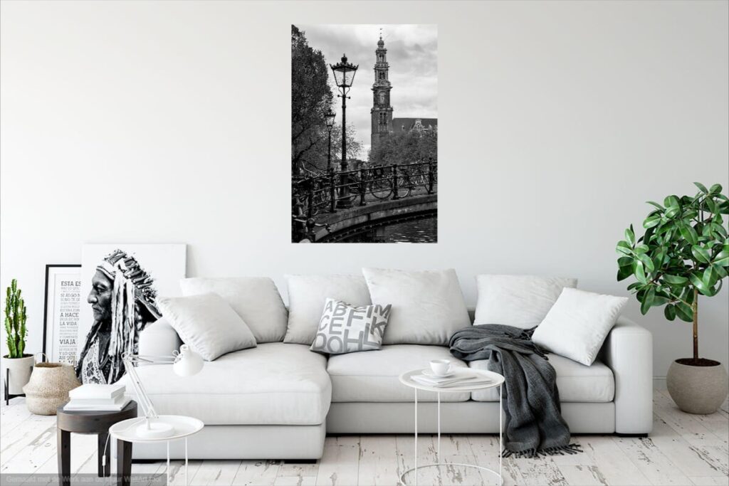 Verticale zwart-wit fotografie van de Westertoren met karakteristieke lantaarnpaal en fietsen aan de gracht.