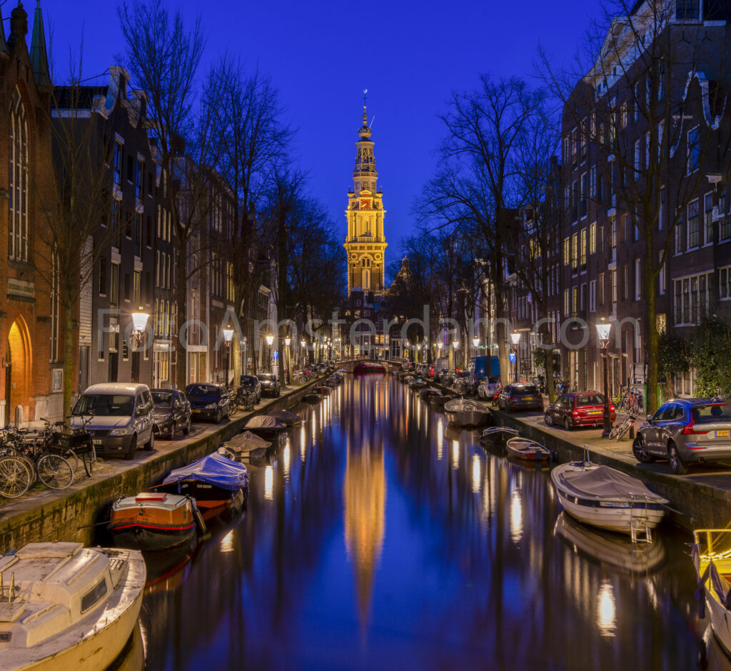 Blue hour view of the illuminated Zuiderkerk reflected in the Groenburgwal canal