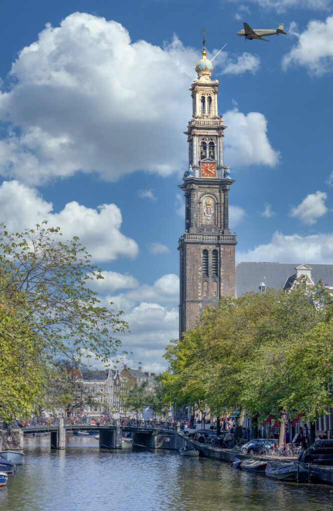 Vintage sightseeing aircraft flying past the Westerkerk tower in Amsterdam