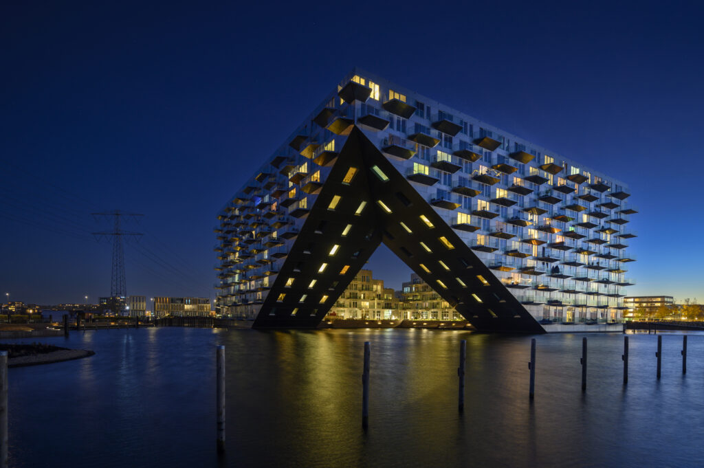 Sluishuis Amsterdam bij avondlicht met reflecties in het water