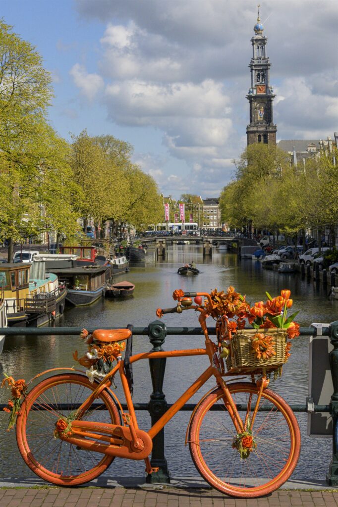 Premium foto Oranje fiets op Amsterdamse brug Cultuur en iconen Amsterdam - Ideaal als fotobehang of naadloos behang op maat